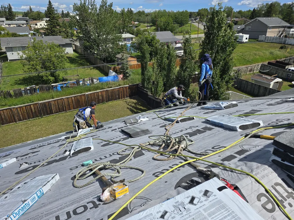 The Raptor crew installing underlayment on a Dawson Creek roof